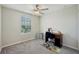 This bedroom features carpeted floors, a ceiling fan, and a bright window for natural lighting at 14460 English Lavender Dr, Wimauma, FL 33598