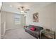 Neutral bonus room featuring a ceiling fan, window and a comfortable grey futon with a 'Blessed' pillow at 14460 English Lavender Dr, Wimauma, FL 33598