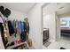 Walk-in closet showing shelving with clothes and shoes, leading into a bathroom at 14460 English Lavender Dr, Wimauma, FL 33598