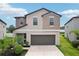 Charming two-story home with a two-car garage, well-manicured lawn, and inviting front entrance at 14460 English Lavender Dr, Wimauma, FL 33598
