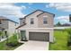 Attractive two-story home with landscaped front yard and a gray two-car attached garage at 14460 English Lavender Dr, Wimauma, FL 33598