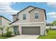 Well-maintained two-story house featuring a two-car garage, green lawn, and inviting front door at 14460 English Lavender Dr, Wimauma, FL 33598