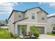 Two-story home with a two-car garage, complemented by lush landscaping and a welcoming front entrance at 14460 English Lavender Dr, Wimauma, FL 33598
