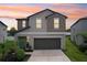 Exterior elevation of a two-story home with a neutral color palette and attached two car garage at 14460 English Lavender Dr, Wimauma, FL 33598