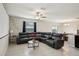 Spacious living room featuring a leather sectional, ceiling fan, and bright tile flooring at 14460 English Lavender Dr, Wimauma, FL 33598