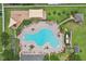 Aerial view of a large community pool with lounge chairs, playground, and lush landscaping at 14460 English Lavender Dr, Wimauma, FL 33598