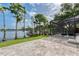 Tiled patio with lake views, mature trees, and pool access at 15012 Maurine Cove Ln, Odessa, FL 33556