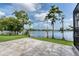 Paver patio overlooking the lake with mature cypress trees and grass at 15012 Maurine Cove Ln, Odessa, FL 33556