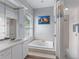 Bathroom featuring jacuzzi tub, walk in shower, and large mirror with great lighting at 15012 Maurine Cove Ln, Odessa, FL 33556