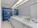 Bright bathroom featuring double sink vanity, updated fixtures, and decorative accents at 15012 Maurine Cove Ln, Odessa, FL 33556