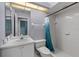 Bright bathroom with shower/tub combo, white tile, and modern fixtures at 15012 Maurine Cove Ln, Odessa, FL 33556