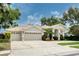 Spacious home with three-car garage, lush landscaping, and an inviting entrance at 15012 Maurine Cove Ln, Odessa, FL 33556
