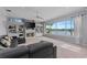 Spacious living room with a fireplace, built-in shelving, a large window overlooking the water, and a comfortable leather sofa at 15012 Maurine Cove Ln, Odessa, FL 33556