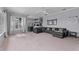 Spacious living room with plush carpeting, modern furnishings and a view into the kitchen at 15012 Maurine Cove Ln, Odessa, FL 33556