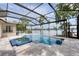 Beautiful pool with an inset spa within a screened enclosure offering a serene lake view from backyard at 15012 Maurine Cove Ln, Odessa, FL 33556