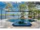 Inviting screened pool with a built-in spa, featuring a lake view at 15012 Maurine Cove Ln, Odessa, FL 33556