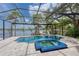 A stunning view of a pool with an inset spa and a screened enclosure, overlooking a serene lake at 15012 Maurine Cove Ln, Odessa, FL 33556