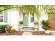 Inviting front entrance with a light green door framed by decorative planters and lush landscaping at 16831 Banner Shell Pl, Wimauma, FL 33598