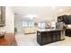Open-concept kitchen and living room with a center island, barstool seating, and stainless steel appliances at 16831 Banner Shell Pl, Wimauma, FL 33598