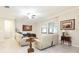 Comfortable living room with two sofas, neutral walls, tile floors, and natural light from the windows at 16831 Banner Shell Pl, Wimauma, FL 33598