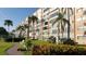 Well manicured multi-story building on a grassy lot, with tropical trees and beautiful landscaping at 1847 Shore Drive S # 415, South Pasadena, FL 33707