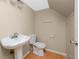 Simple bathroom with a pedestal sink, toilet, and tiled floor at 1881 Lichen Ln # B, Clearwater, FL 33760