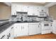 Updated kitchen with stone backsplash, stainless sink, and sleek white appliances at 1881 Lichen Ln # B, Clearwater, FL 33760