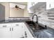 Modern kitchen with white cabinets, dark hardware, designer countertops, and stainless steel sink at 1881 Lichen Ln # B, Clearwater, FL 33760