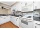 Bright kitchen view showcases white cabinets, appliances, stone backsplash, and dining area at 1881 Lichen Ln # B, Clearwater, FL 33760