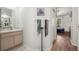 Bathroom with wood floors leading to bedroom and a modern sink with wood cabinets at 19104 Cellini Pl, Lutz, FL 33558