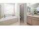 Bright bathroom features a soaking tub, neutral tile, and a separate toilet room at 19104 Cellini Pl, Lutz, FL 33558