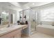 Bathroom with a glass-enclosed shower, a separate soaking tub, and dual sinks at 19104 Cellini Pl, Lutz, FL 33558