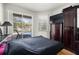 Bedroom overlooking the pool with hardwood floors and a large dresser with a TV at 19104 Cellini Pl, Lutz, FL 33558