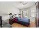 Bedroom with hardwood floors, ceiling fan, dresser, and sliding door to the pool area at 19104 Cellini Pl, Lutz, FL 33558