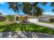 Charming single-story home featuring a well-manicured lawn, mature palm trees, and a two-car garage at 19104 Cellini Pl, Lutz, FL 33558