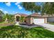 Beautiful home with lush landscaping, mature palm trees, and a two-car garage on a sunny day at 19104 Cellini Pl, Lutz, FL 33558