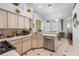 Well-lit kitchen with cream colored cabinetry, modern appliances, tile floors, and eat-in nook at 19104 Cellini Pl, Lutz, FL 33558