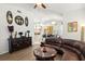 Living room featuring a brown leather sofa, round coffee table, and decorative wall art at 19104 Cellini Pl, Lutz, FL 33558