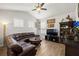 Spacious living room features a brown leather sofa, ceiling fan, and dark wood accents at 19104 Cellini Pl, Lutz, FL 33558