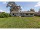 Spacious backyard featuring a lush lawn and mature trees, ideal for outdoor activities and relaxation at 212 Gay Rd, Seffner, FL 33584