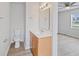 Bright bathroom featuring a vanity with storage, a toilet, and a glimpse into an adjacent, airy bedroom at 212 Gay Rd, Seffner, FL 33584