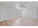 Well-lit bedroom featuring wood-look floors, a ceiling fan, and a bright white door at 212 Gay Rd, Seffner, FL 33584