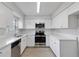 Bright kitchen with stainless steel appliances, granite countertops, and white cabinets at 212 Gay Rd, Seffner, FL 33584