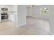 Open-concept living room and kitchen with new wood flooring and fresh, white paint at 212 Gay Rd, Seffner, FL 33584