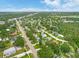 Gorgeous aerial view showcases a neighborhood, featuring tree-lined streets and various houses with mature trees at 2160 Ne Coachman Rd, Clearwater, FL 33765