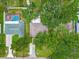 Aerial view of home with a pool and mature trees providing shade and privacy at 2160 Ne Coachman Rd, Clearwater, FL 33765