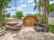 Inviting backyard featuring a hot tub, shed, outdoor seating, barbecue grill, and brick pavers at 2160 Ne Coachman Rd, Clearwater, FL 33765