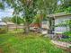 Backyard featuring a jacuzzi, covered wooden shed, small shed, outdoor seating, and a large grassy area at 2160 Ne Coachman Rd, Clearwater, FL 33765