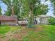 A view of the house's backyard, a jacuzzi, and two sheds, with a bicycle casually leaning against a tree at 2160 Ne Coachman Rd, Clearwater, FL 33765