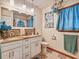 Well-lit bathroom featuring double sinks, granite countertops, custom mirror, and decorative tile flooring at 2160 Ne Coachman Rd, Clearwater, FL 33765